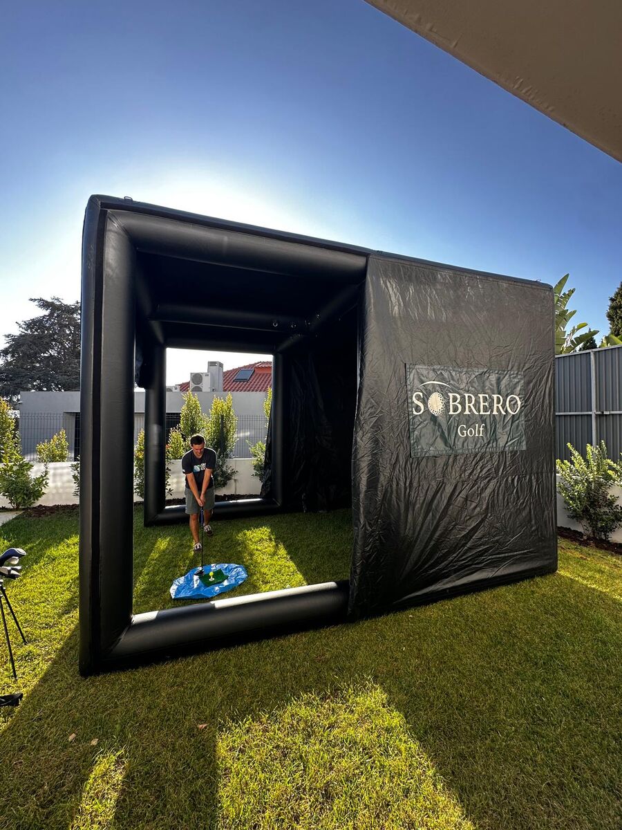 Vista lateral da tenda compacta da Sobrero Golf, com o logótipo e um jogador lá dentro