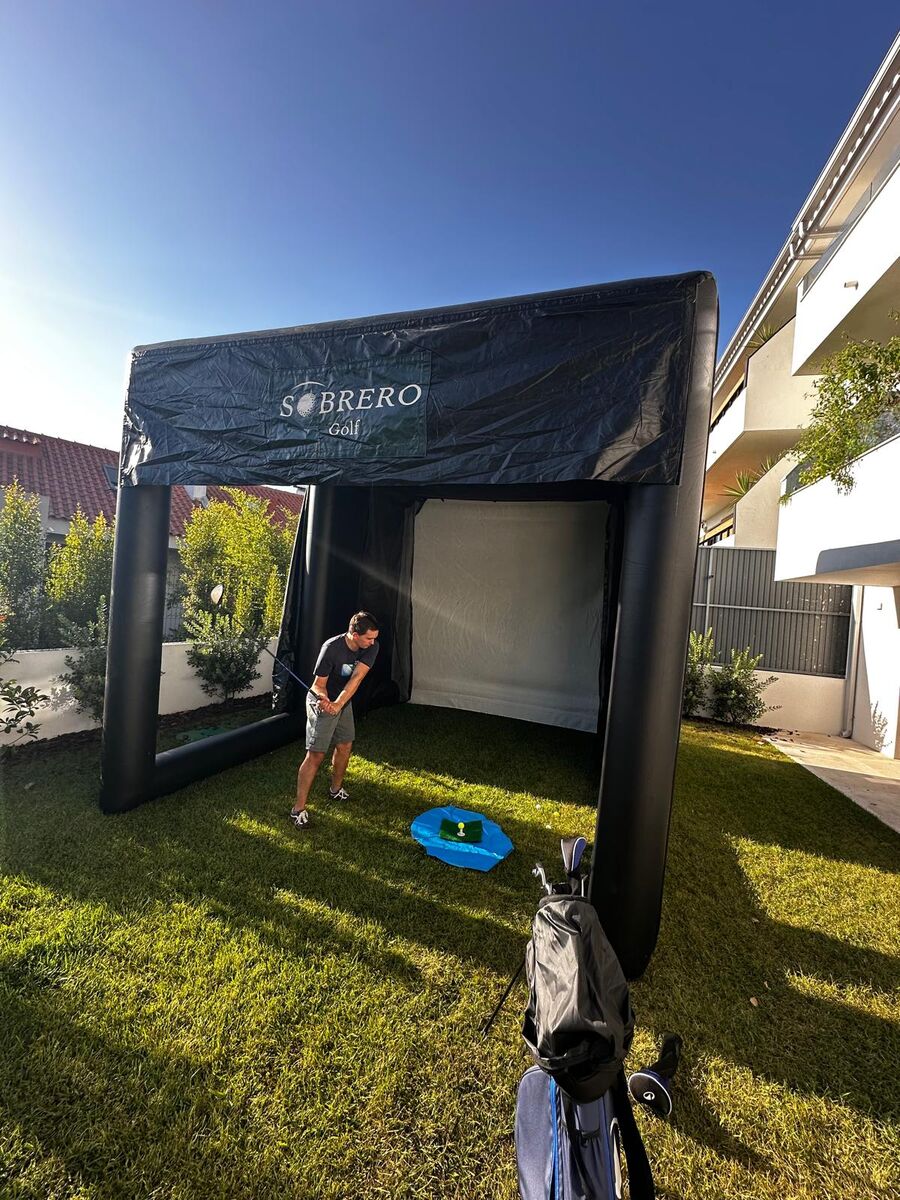 Um jogador a dar uma pancada dentro da tenda compacta da Sobrero Golf